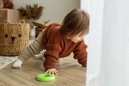 Toddler child is playing with toys on floor in room. Childhood, kindergarten and development...