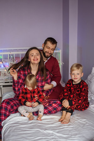 family sitting with their little girl and boy at home. Concept of family, care and spending time togetherの写真素材