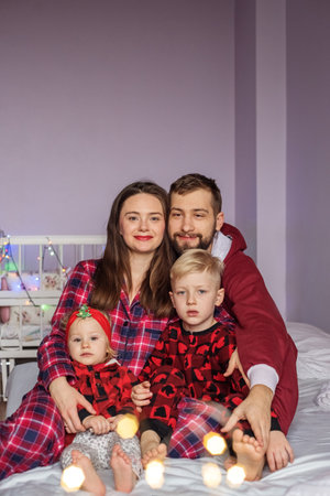 happy family with little children lying on bed at home. Concept of family, care and spending time togetherの写真素材