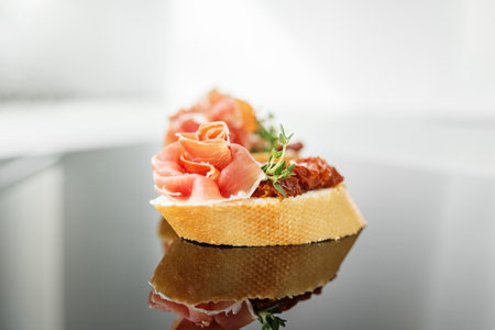 Appetizer with prosciutto, bruschetta and sun-dried tomato. Food, restaurant and event concept. Close-up.の写真素材