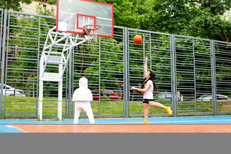 Concept of sports, hobbies and healthy lifestyle. Young people playing basketball on playground outdoorsの写真素材