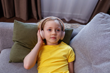Happy child listens to music or audiobook. Little school kid wearing headphones. Music makes my dayの写真素材