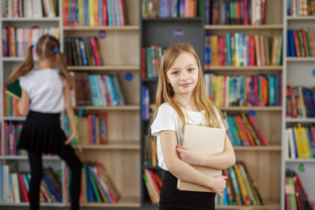 Child buys books in bookstore for learning or reading. Girl choosing book in school library. Benefits of everyday reading.の写真素材