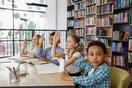 Classmates study in classroom. Back to school. Multi-ethnic pupils study and write at table in library or classroom.の写真素材