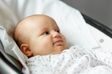 Newborn concept. Close up portrait of newborn on baby swing in room.の写真素材