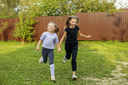 Two children run in backyard in summertime. Childhood and vacation concept.の写真素材
