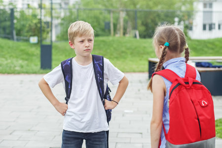 Back to school. Two children, classmates, quarrel and yell on way from school. Bad mood. Negative emotion. Upbringing and family concept.の写真素材