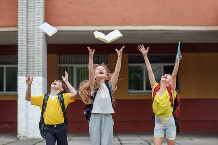 Back to school. Beginning of school lessons. Three school children having fun outdoors. Classmates with backpacksの写真素材