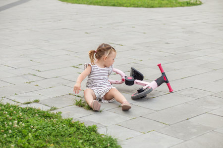 Toddler girl driving balance bike outdoors. Learning to ride bikeの写真素材