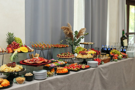 catering buffet table with snacks and appetizers. Set of varios fruits and berries. Decorative vase....