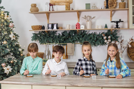 Group children draws food paints on Christmas homemade gingerbread cookies. Christmas concept.の写真素材