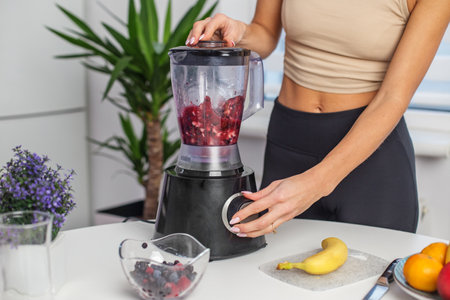 Healthy food concept. Close up of woman prepare to blending berries to make smoothie at home kitchenの写真素材