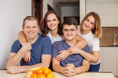 Smiling family of four enjoying a fun moment together in the comfort of their stylish, modern...