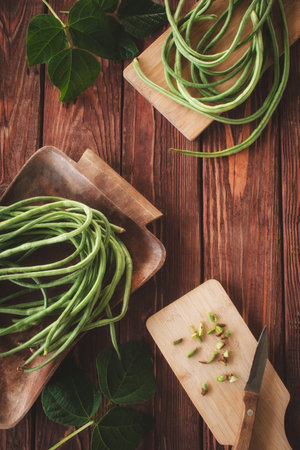 Fresh raw asparagus or cowpea laid out on two wooden cutting boards. Organic, healthy food. Top view.の写真素材