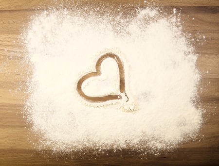 White flour on the table with drawing heartの写真素材