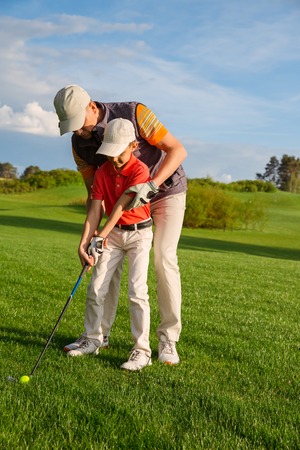 Father with son are training at golf courseの写真素材