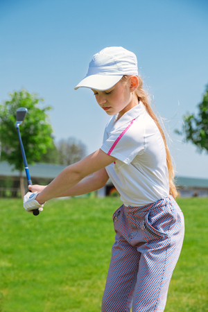 Girl golf player practicing in golf schoolの写真素材