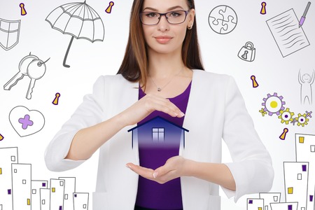 smiling woman holding virtual house in her hands. insurance conceptの写真素材
