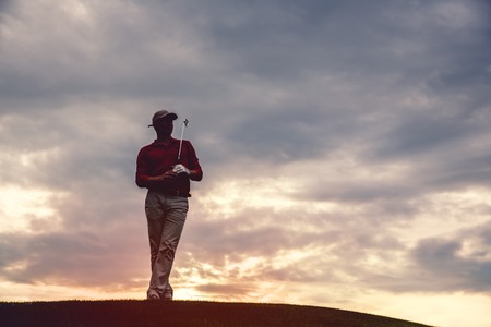 silhouette of man golfer with golf club at sunset