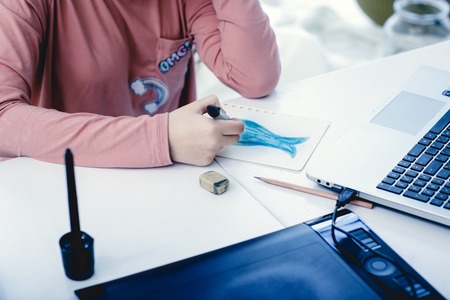 Girl drawing on paper at her study table