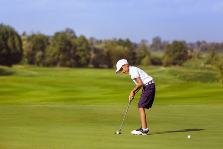 Boy playing golfの写真素材