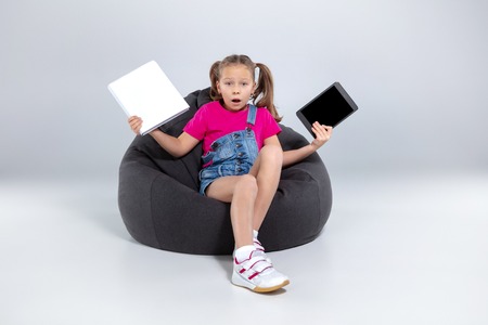 little schoolgirl choosing between smartphone or book