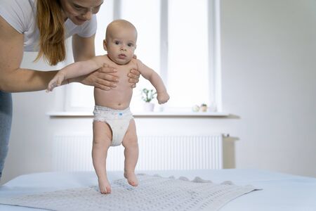 Mother and her baby son having fun and playing at home