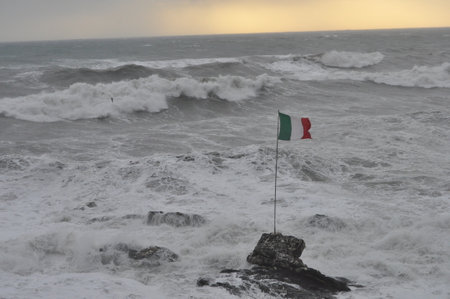 Italy Flag on the rock, sea of Genoa, Liguria, Italyの写真素材