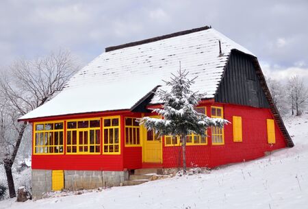 Rustic colored house with snow on the roof, Romaniaのeditorial素材