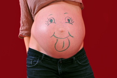 Pregnant belly with funny face drawingの写真素材