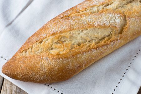 Rustic french baguette on a white kitchen towel