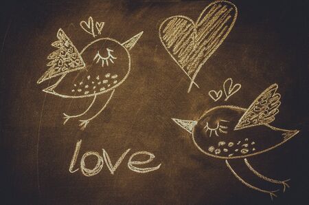 Hand drawing with chalk on blackboard, cute kawaii birds, heart and word love, template for greeting card, poster, wallpaper, St. Valentines, romanticの写真素材