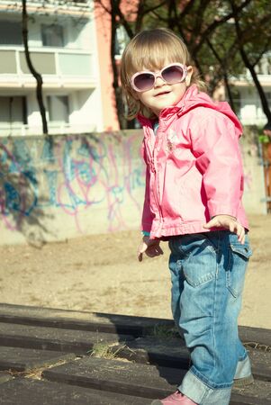 Portrait of a beautiful little girl outdoor in sunglasses.の写真素材