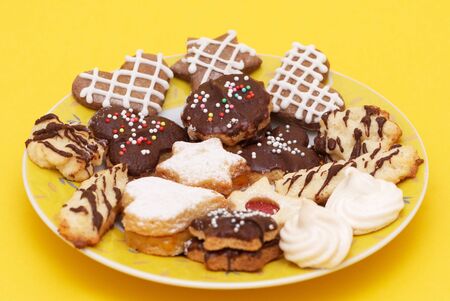 A group of Christmas cakes on yellow plate and yellow backgroundの写真素材