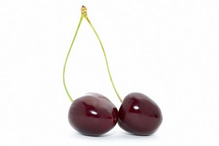 Two cherries with a stem on white backgroundの写真素材