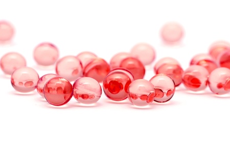 Transparent red capsules isolated on whiteの写真素材