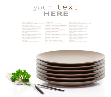 Stack of brown round plates with fork, spoon and parsley (with sample text)
の写真素材