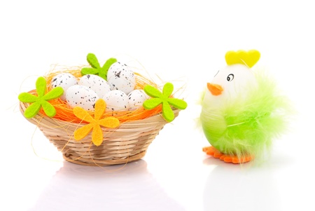 Easter eggs in basket and decorative chicken isolated on white backgroundの写真素材