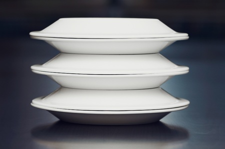 A stack of white plates on a tableの写真素材