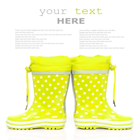 Yellow rubber boots for kids isolated on white background  with sample text の写真素材