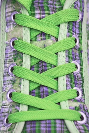 Closeup of a sneaker with green shoelaces, abstract backgroundの写真素材