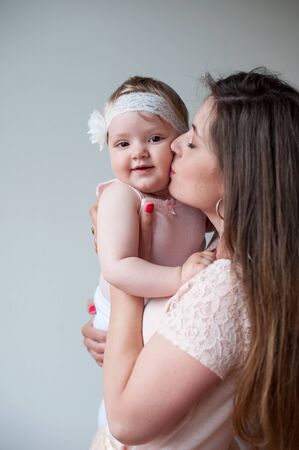 Family, child and parenthood concept - happy mother kissing her smiling babyの写真素材