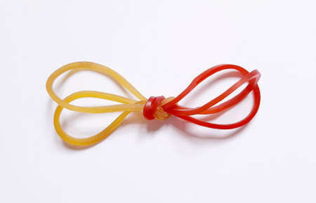 Two different color elastic bands tied together isolated on white background