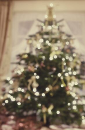 Decorated christmas tree in a home in the lounge the lights are on creating a bokeh effect.の写真素材