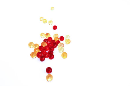 Vitamins. Red and yellow transparent capsules with a white background.