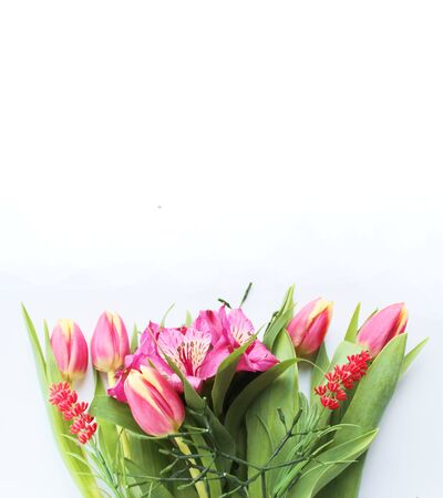 A delicate spring bouquet of scarlet tulips and crimson Alstroemeria. Background for greetings, invitations, and postcards.の写真素材
