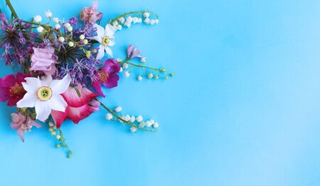 Daffodils, roses and lilies of the valley on a blue background. Spring flower arrangement. Bright color. Background for cards, greetings, invitations.の写真素材