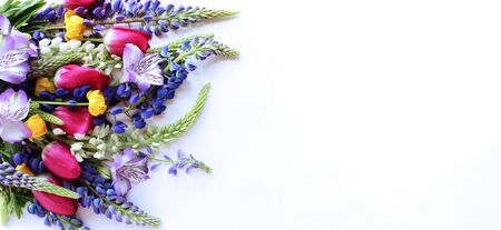 Summer bouquet of flowers. Purple lupines, crimson tulips and lilac astromeria on a white...