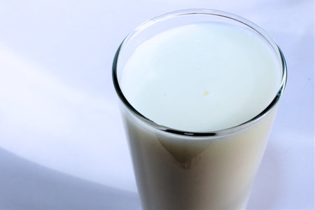Milk in a glass on a white background, close-upの写真素材