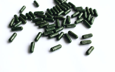 Green pills on white background. Close up. Health care concept.の写真素材
